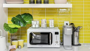 A kitchen with a microwave, coffee maker, and various kitchenware on the counter. - Colorful private guesthouse in charming Richmond with Parking (Richmond)