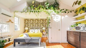A bright bedroom with a bed, bedside table, and a window. - Colorful private guesthouse in charming Richmond with Parking (Richmond)