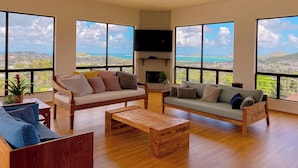 Un salón espacioso con ventanas amplias, una chimenea y una mesa de centro de madera.