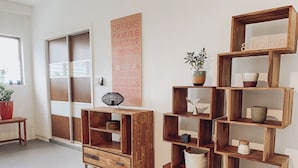 Una habitación con un armario de madera, una pared con un cartel, y una estantería con objetos decorativos.