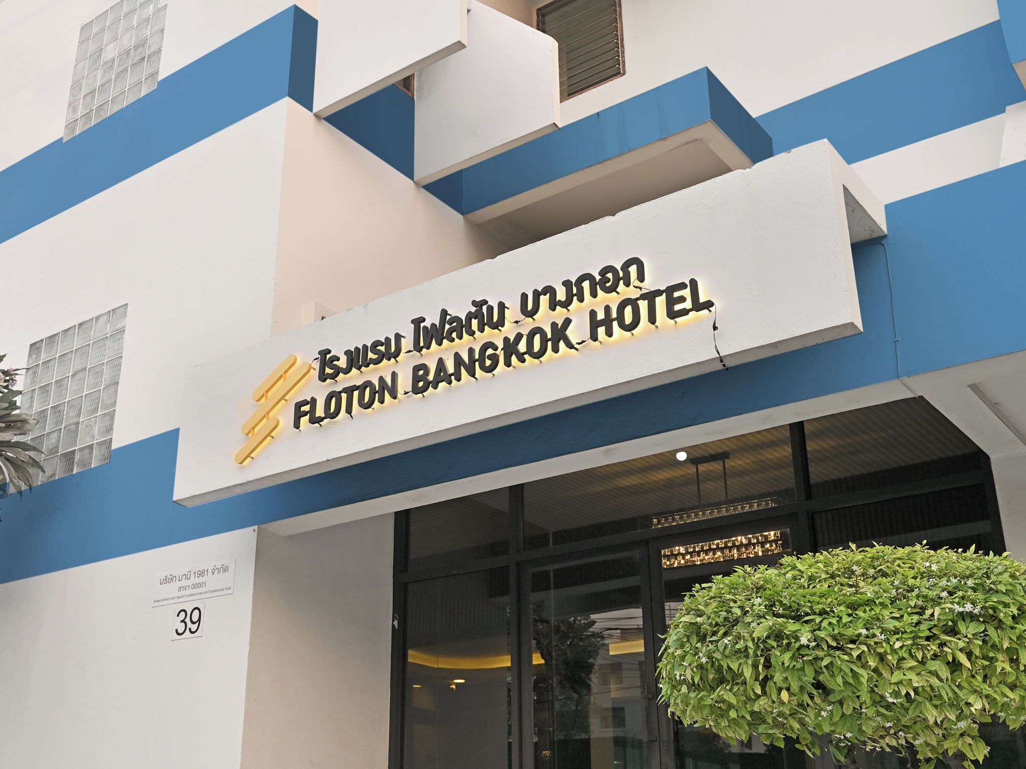 The exterior of the Flotton Bangkok Hotel with a sign displaying its name in both Thai and English.