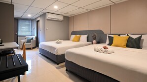 A hotel room with two beds, a desk, and a chair.