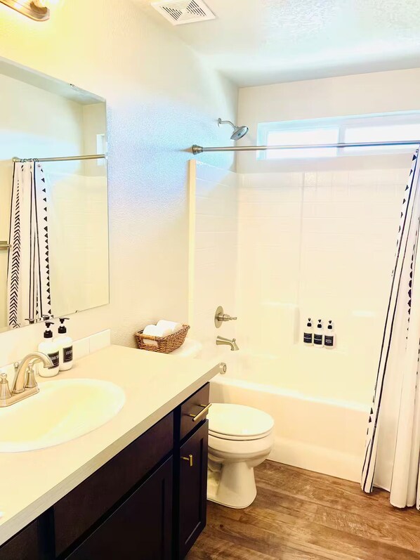 Une salle de bain avec deux lavabos, des toilettes, une douche et un miroir.