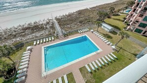 A swimming pool with lounge chairs, a beach view, and a building with balconies. - Sunswept 705  Beach Front - King Bed -  POOL - Orange Beach  (Orange Beach)