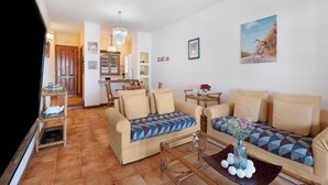 A cozy living room with two sofas, a coffee table, and a dining area with a small table and chairs. - Ocean View-2 Bed-Sleeps 4-Pueblo Marinero (Acantilados de Los Gigantes)