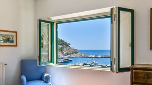 Ein Zimmer mit großem Fenster mit Blick auf einen Yachthafen und Gebäude.