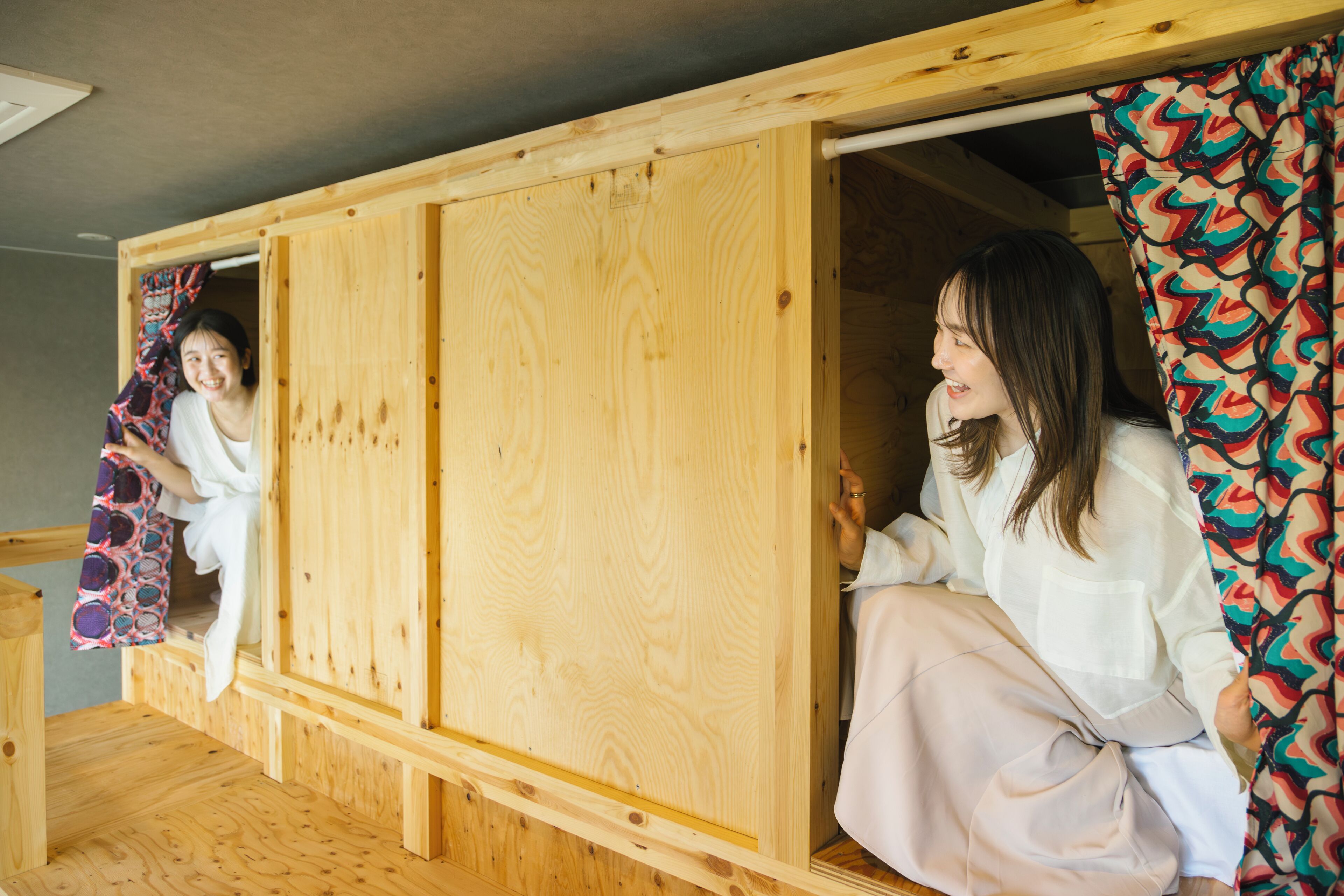 Una habitación de madera con una puerta corredera y una cortina colorida.