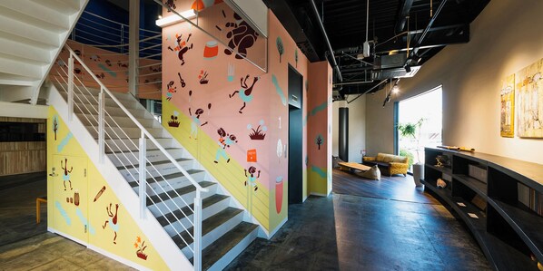 Un interior moderno con una escalera, paredes coloridas y una zona de estar.