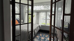 Una habitación con cama, ventana y vista al exterior.