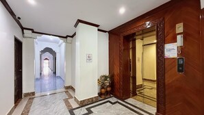 A hotel lobby with a marble floor, a wooden reception desk, and a no smoking sign. - Vangvieng Sisavang Hotel (Vang Vieng)