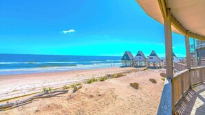 A beach view with wooden beach huts and a sandy beach. - Starfish Beachfront Swim-Up with HOT TUB (Surfside Beach)