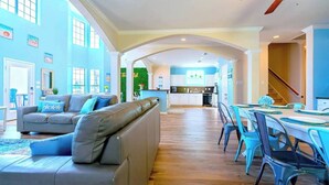 A spacious living room with a large sofa and a dining area with a table and chairs. - Starfish Beachfront Swim-Up with HOT TUB (Surfside Beach)