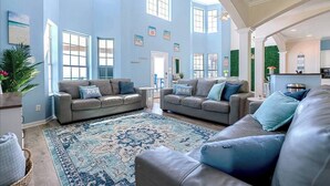 A spacious living room with two sofas, a patterned rug, and large windows allowing natural light. - Starfish Beachfront Swim-Up with HOT TUB (Surfside Beach)