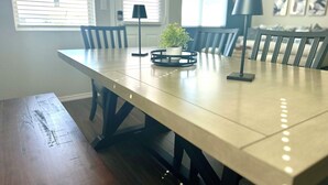 Una mesa de comedor con sillas, un banco y dos lámparas de pie.