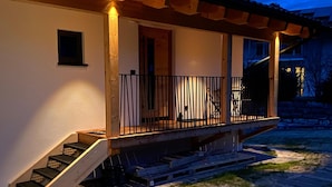 Een gebouw met een houten trap die uitkomt op een veranda met een leuning.