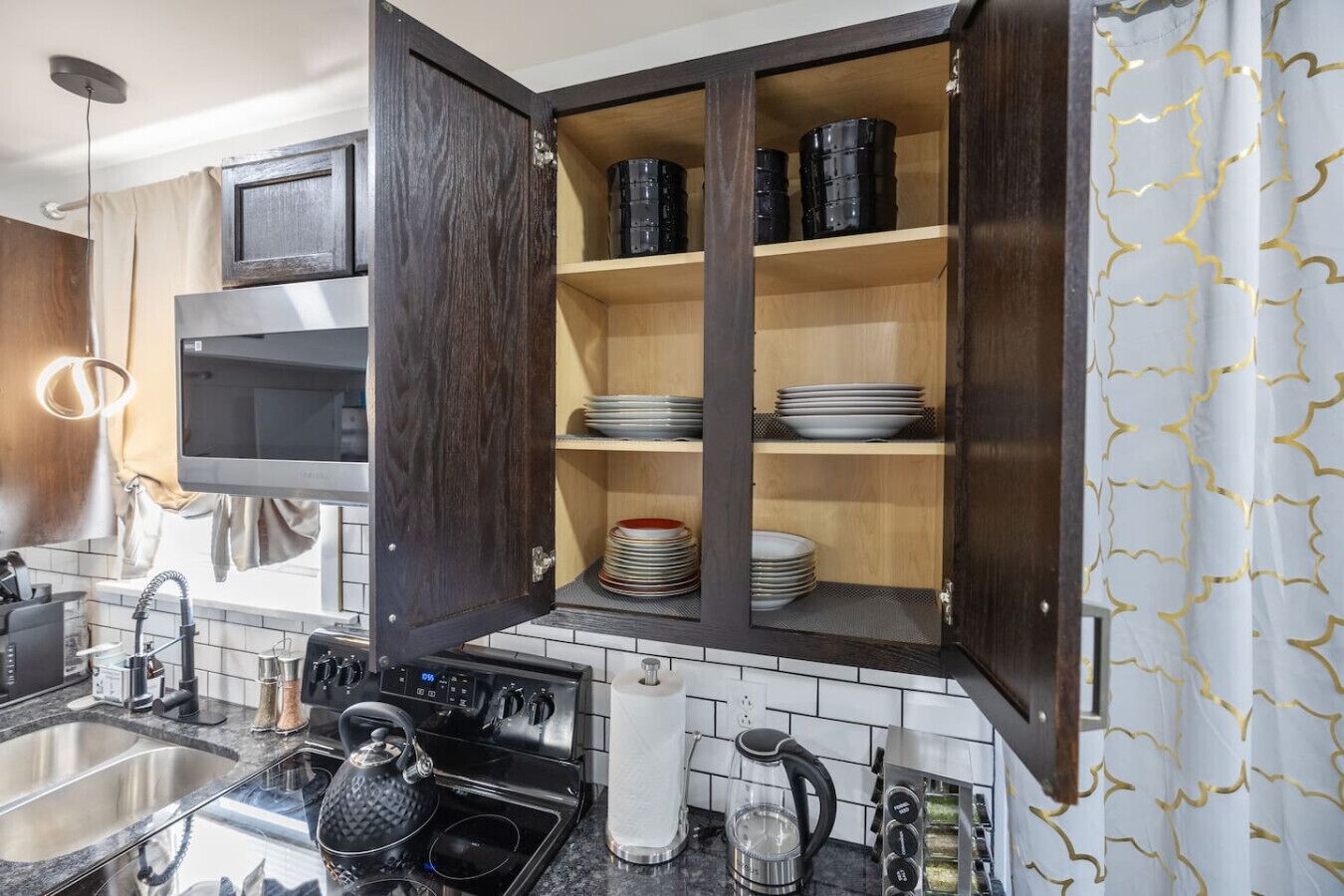 A kitchen with dark wooden cabinets, a stainless steel stove, and a tiled backsplash.
