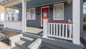 A two-story house with a red front door, white railings, and a grey exterior. - Spacious Bungalow Retreat Near Belle Isle, RVA! (Richmond)