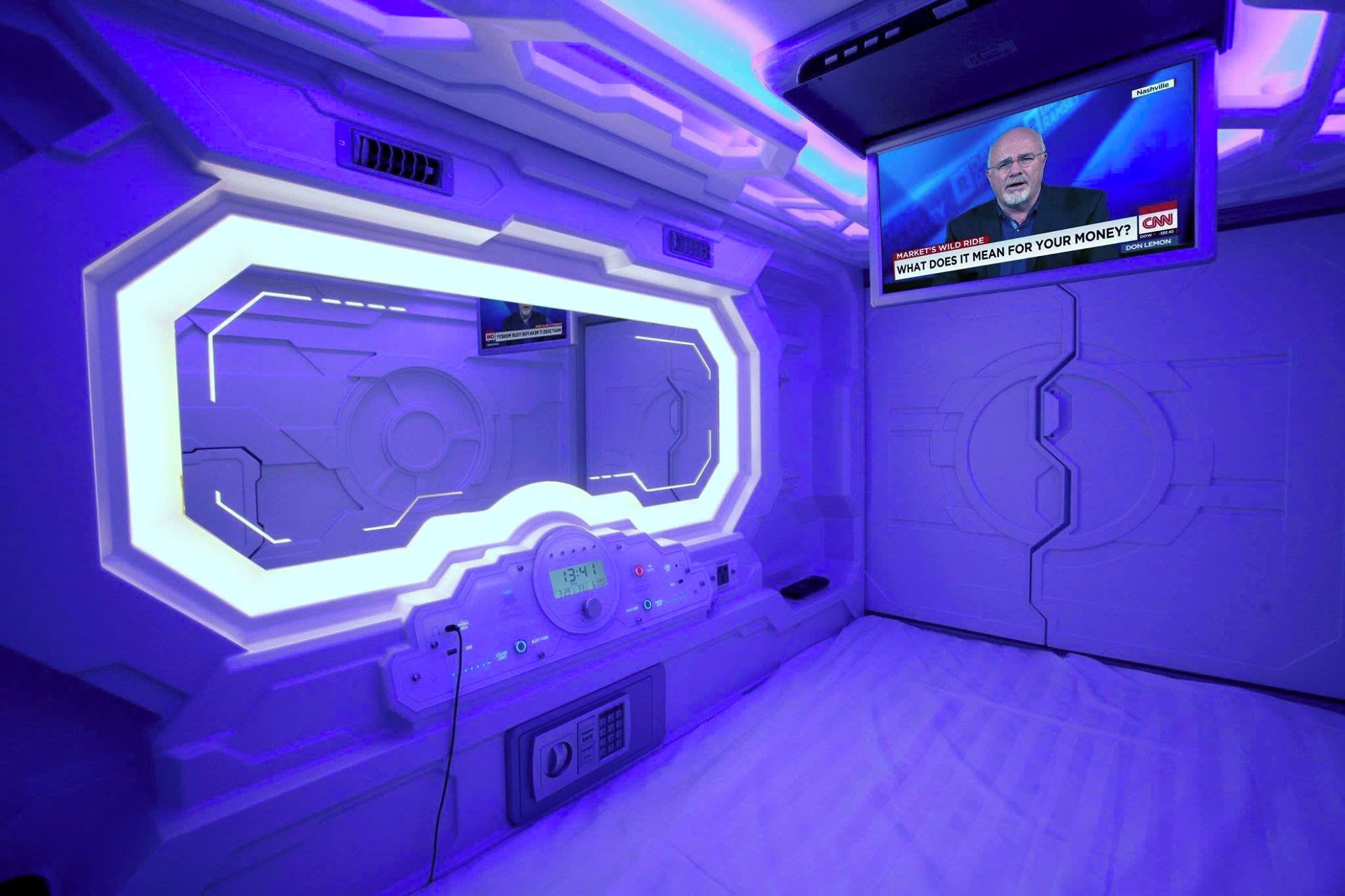 Ein Zimmer mit futuristischem Design, ausgestattet mit einer großen digitalen Anzeige und einer Bedienkonsole.