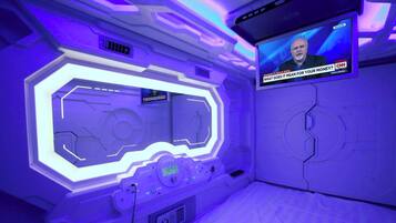Ein Zimmer mit futuristischem Design, ausgestattet mit einer großen digitalen Anzeige und einer Bedienkonsole.