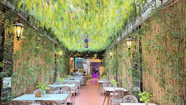 Een restaurant met bamboe wanden en hangende planten, met tafels en stoelen in modern design.
