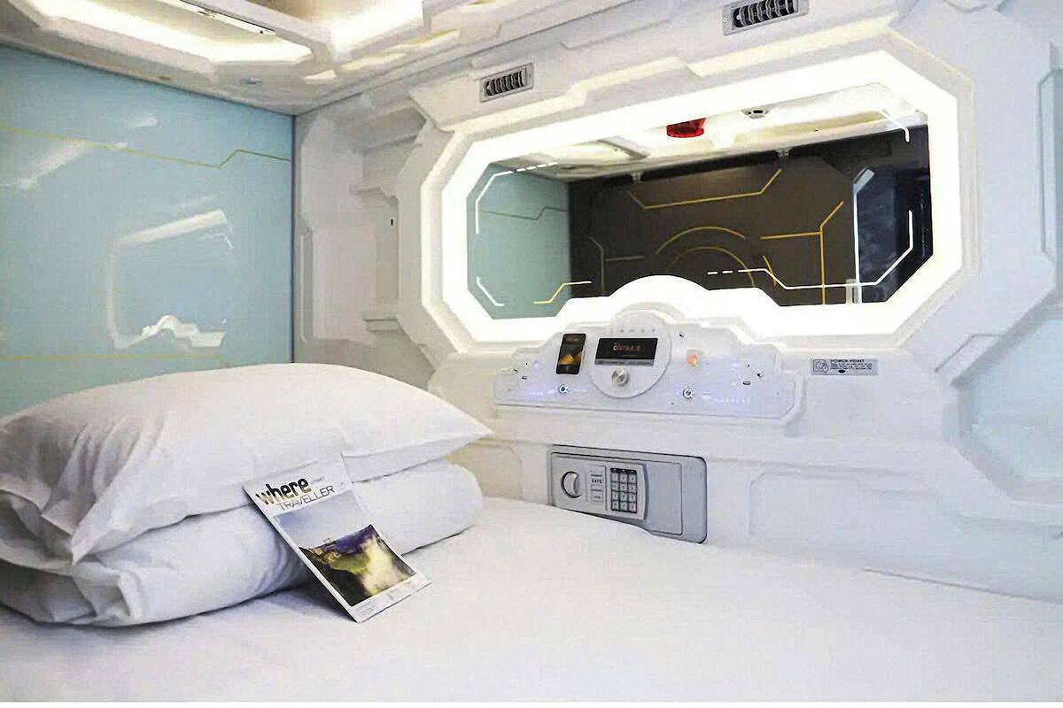 Quarto moderno com uma cama, um painel de controle e uma janela com design geométrico.