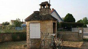 Una costruzione in pietra con una piccola porta e una bicicletta parcheggiata davanti.