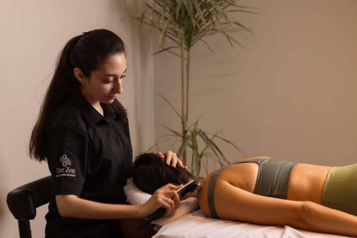A person lying on a bed receiving a massage from another individual.