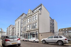A multi-story building with a classical architectural style, featuring a prominent entrance with large windows and a decorative facade.