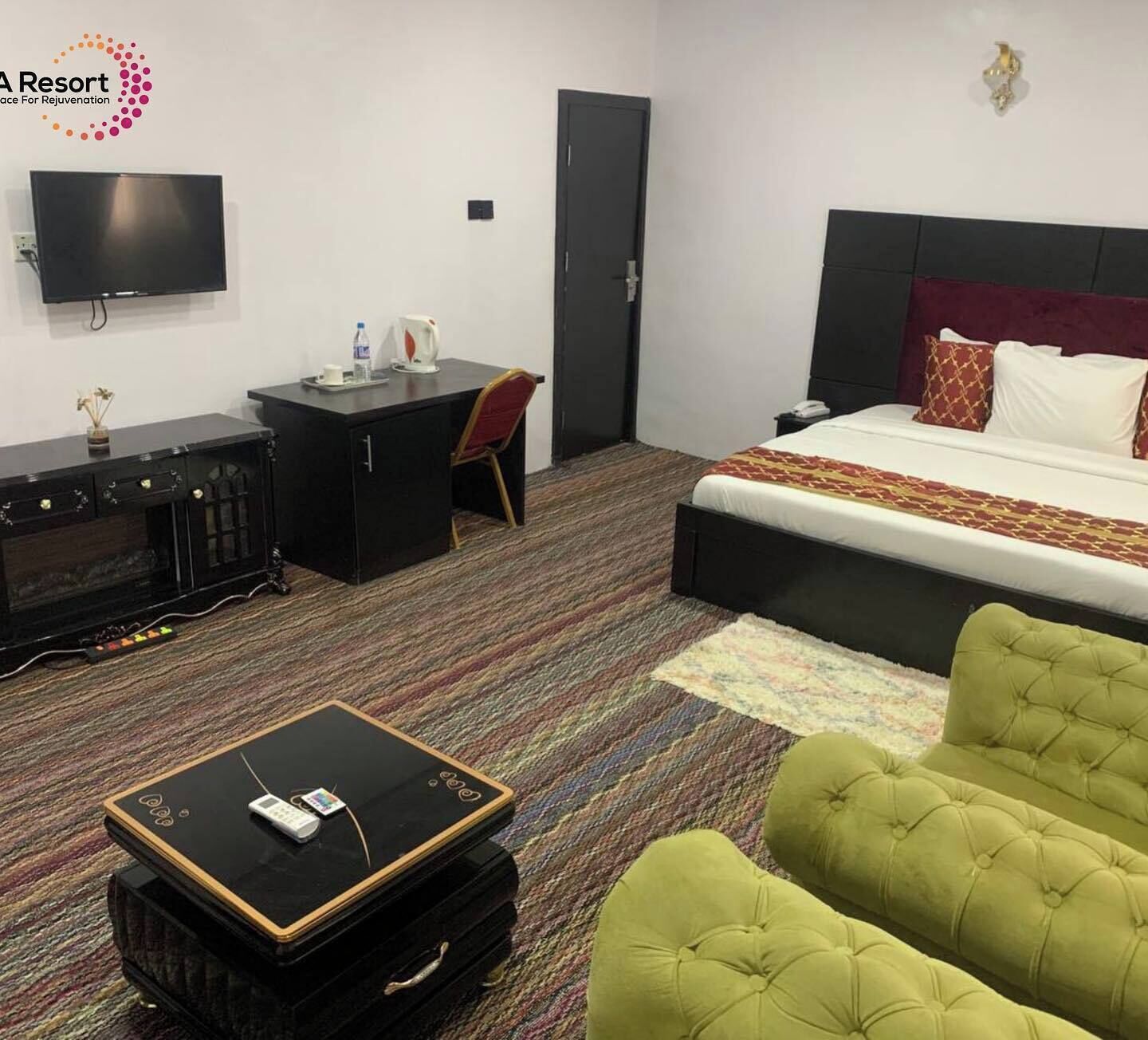 Een hotelkamer met een bed, een bureau, een televisie, een stoel en een koffer.