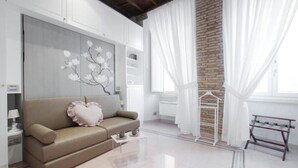 Una sala de estar moderna con un sofá color beige, una mesa de centro y una estantería de pared.