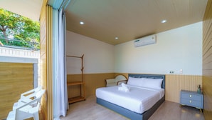 A bedroom with a bed, a nightstand, a chair, and a wooden shelf. - Cozy gray garden (Pattaya)
