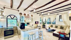 Amplia sala de estar con cocina, una isla grande y un rincón de descanso acogedor.