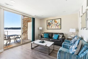 Ein Wohnzimmer mit einer Couch, einem Couchtisch und Blick auf eine verschneite Landschaft durch eine Glastür.