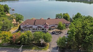 Ein mehrstöckiges Hotel mit Innenhof, umgeben von Bäumen und einem großen Wasserspiegel.