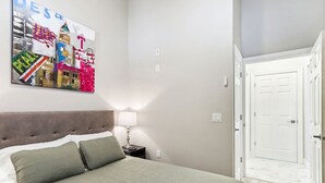 Ein Schlafzimmer mit Bett, Nachttisch, Lampe und Tür.