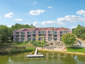Un hotel de varios pisos con un patio central, un muelle y un estanque.