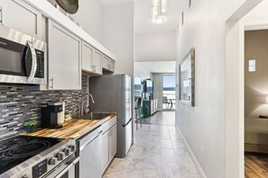 A modern kitchen with a stainless steel range, a coffee maker, and a microwave. - Luxury Beachfront Retreat at Delton Grand (Wisconsin Dells)