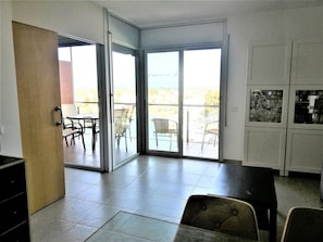 A room with a sliding glass door leading to an outdoor area with chairs and a table.