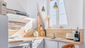 A modern kitchen with a built-in oven, a coffee machine, and a window with a view.