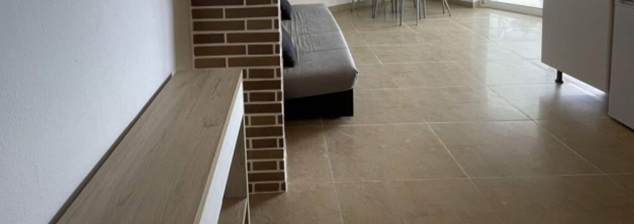 Una cucina moderna con un bancone e una parete decorata con mattoni.