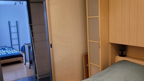A bedroom with a bed, a wardrobe, and a door leading to another room. - Quiet and relaxing apartment in Coxyde, 5 minutes walk from the beach (Koksijde)