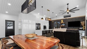 Una cocina moderna con armarios blancos, un refrigerador negro y un horno empotrado.