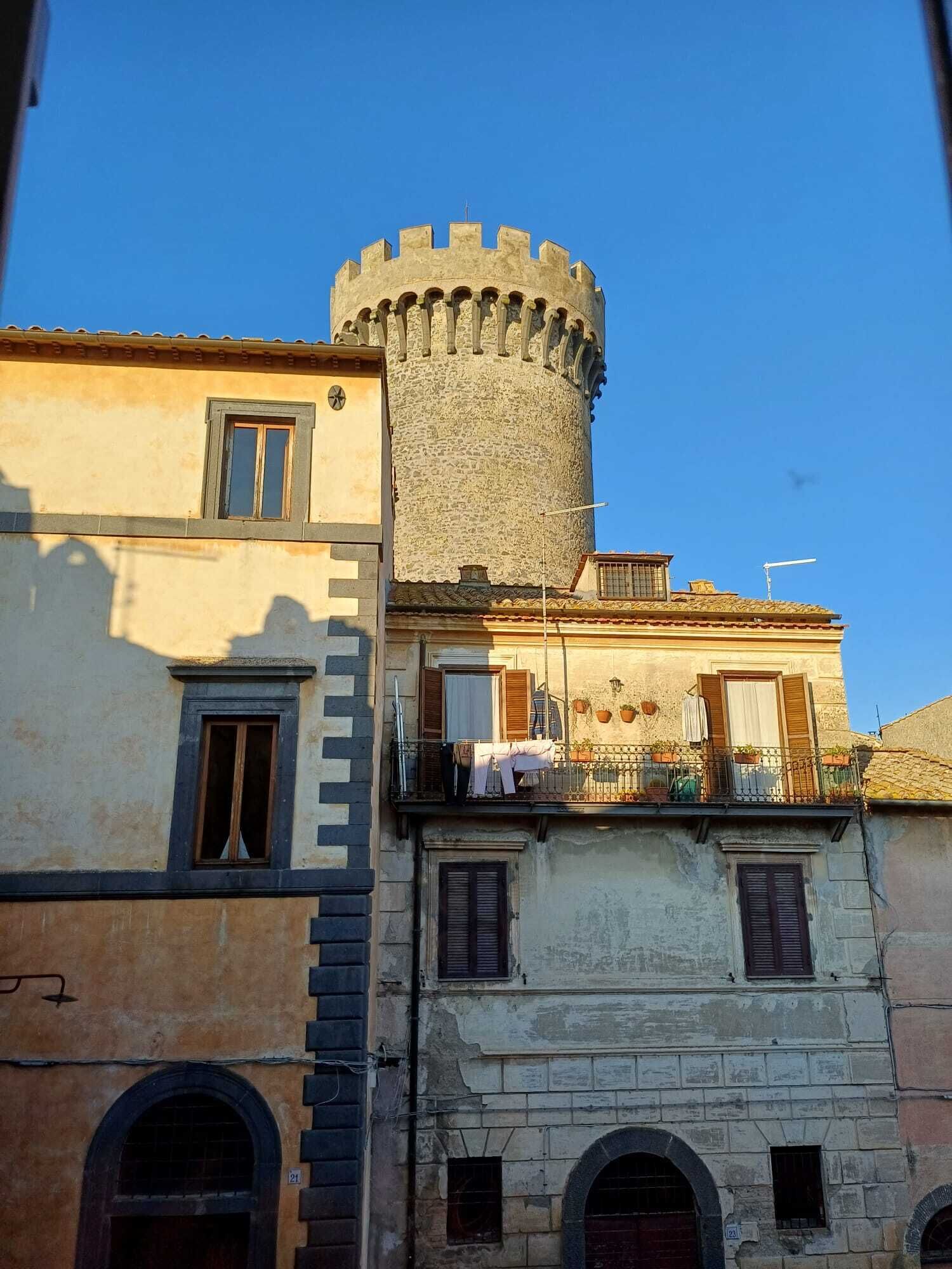 Ein historisches Gebäude mit einem markanten Turm und zahlreichen Fenstern.