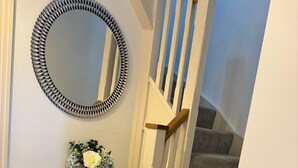 A staircase with a wooden handrail and carpeted steps.