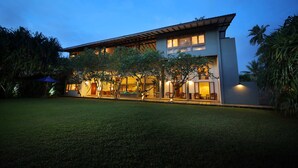 Et moderne hus med to etager, en velholdt græsplæne og en patio.