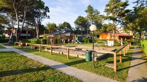 Ein Spielplatz mit Rutsche, Schaukeln und Sandkasten.