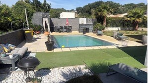 A backyard with a swimming pool, outdoor seating, and a barbecue area. - Villa with private pool in a quiet location 10 min from Avignon (ROCHEFORT DU GARD)