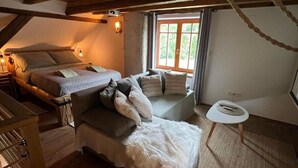 Ein gemütliches Schlafzimmer mit einem Bett, einer Couch und einem kleinen Tisch.