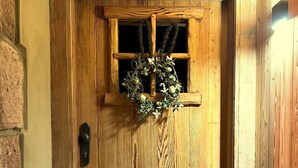 Eine Holztür mit Fenster, einer Girlande und einer Fußmatte.