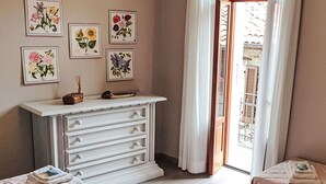 Un dormitorio con dos camas, un aparador y una obra de arte floral en la pared.